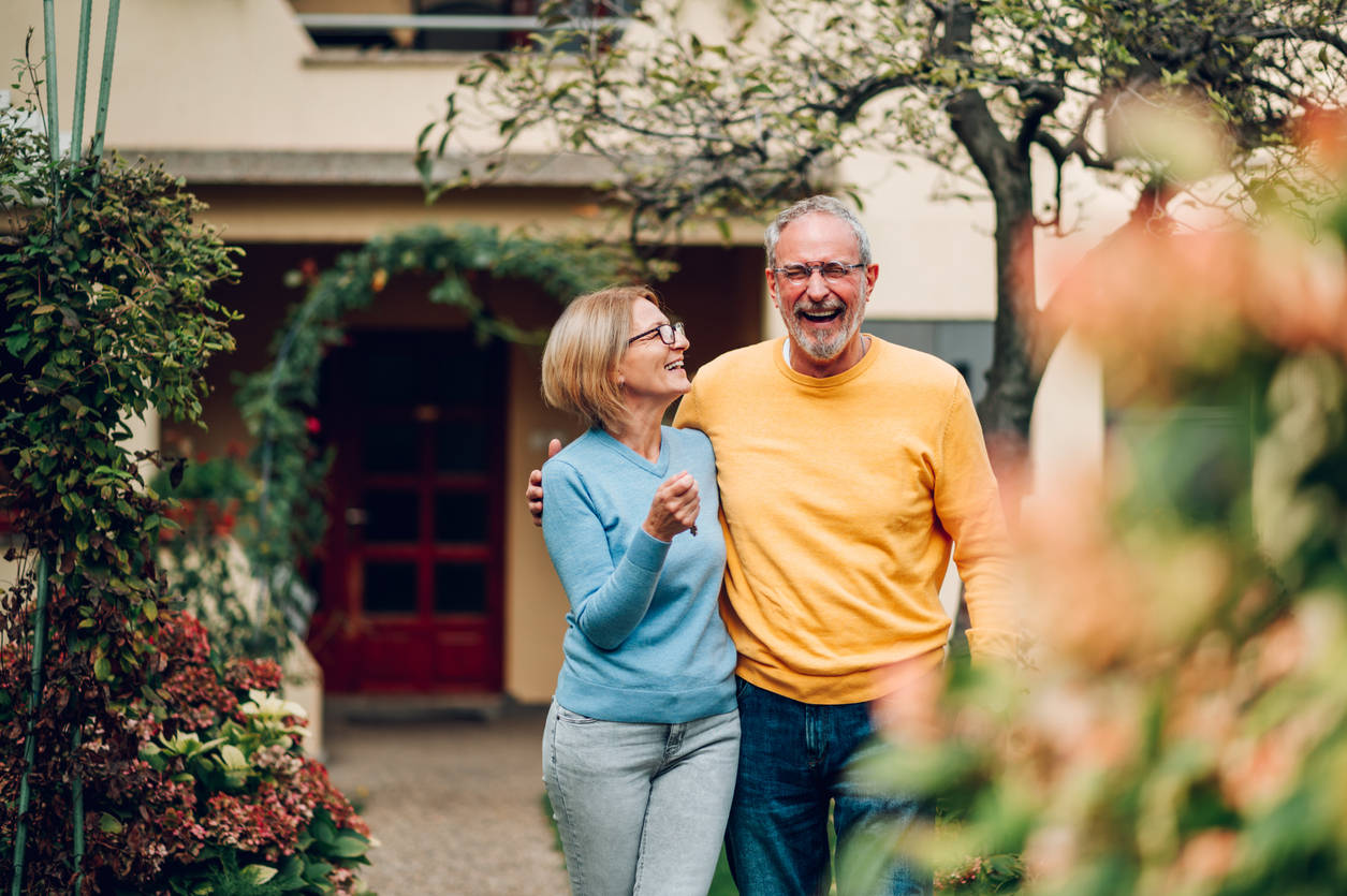 senior couple outside their accommodation during their family trip