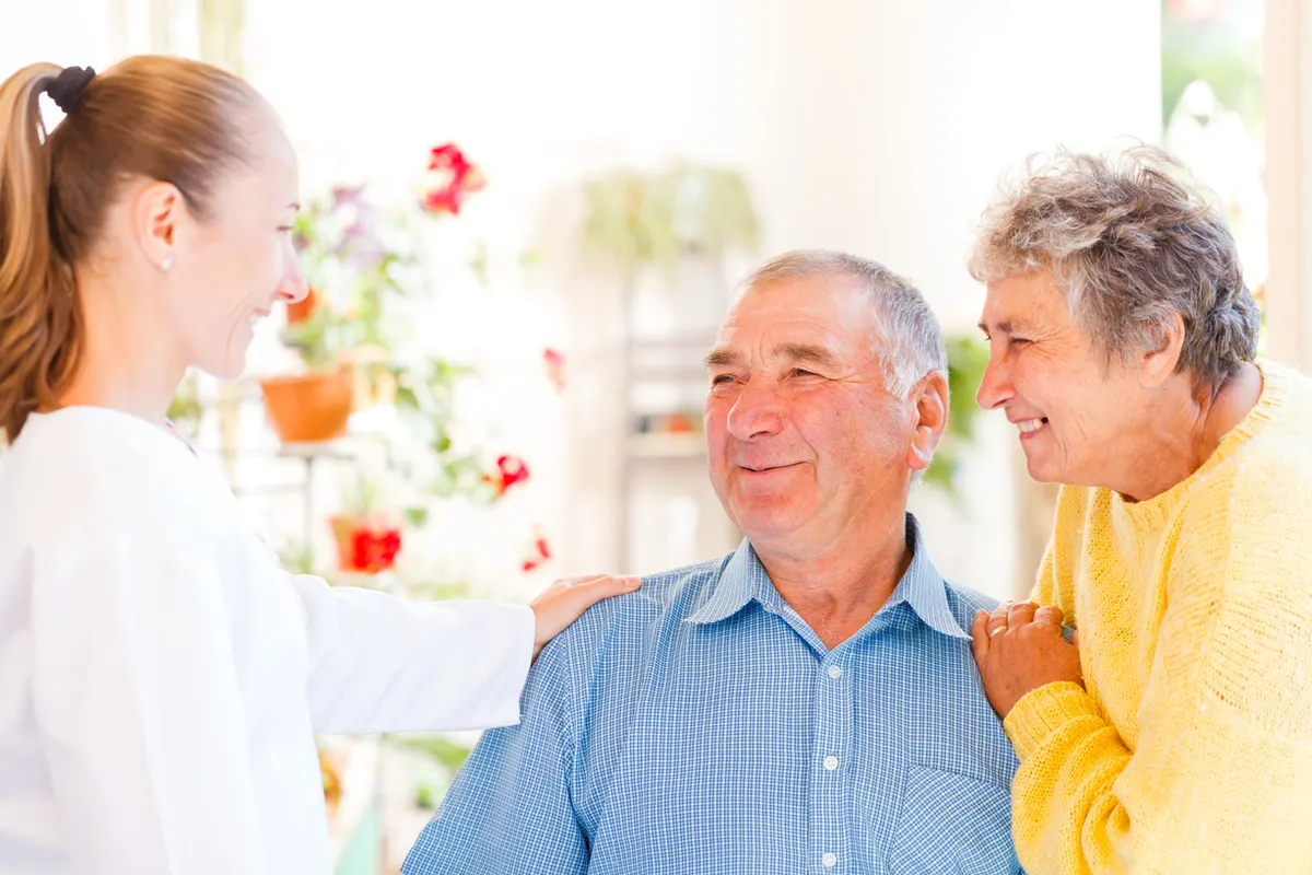 How to talk to your parent about assisted living - A caring adult child and parent talking calmly at home.